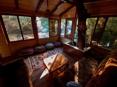 a living room with a table and chairs in a cabin at Sojenica Pustolov - Ada Bojana in Ulcinj