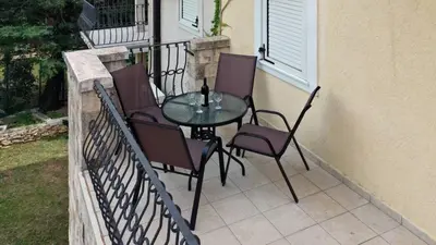 a patio with a table and chairs on a balcony at Family Beachfront Apartment in Petrovac na Moru