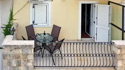 a balcony with two chairs and a glass table at Family Beachfront Apartment in Petrovac na Moru