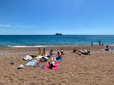 a group of people laying on a beach at Family Beachfront Apartment in Petrovac na Moru