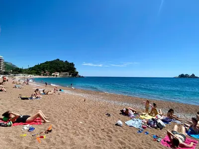 a group of people laying on a beach at Family Beachfront Apartment in Petrovac na Moru