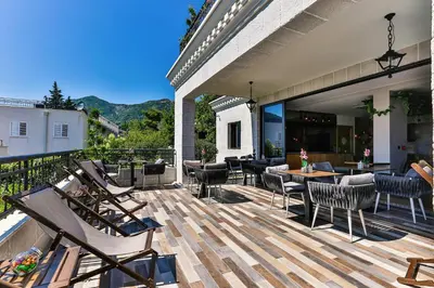 a deck with chairs and tables on a house at Boutique Hotel Tate By Aycon in Budva