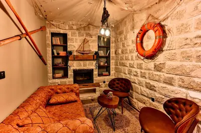 a living room with a couch and a stone wall at Boutique Hotel Tate By Aycon in Budva