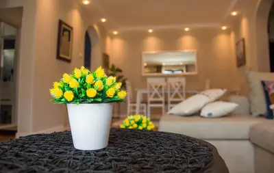 a vase of yellow flowers on a table in a living room at Ana's Place in Kotor