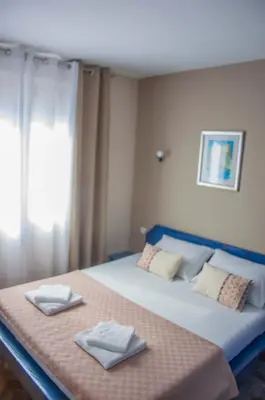 a bedroom with a bed with two towels on it at Ana's Place in Kotor