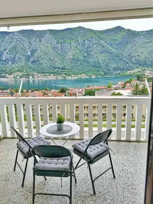 a balcony with a table and chairs and a view of the mountains at Ana's Place in Kotor
