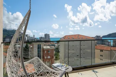 a swinging chair on the balcony of a building at Apartment Tulip of Becici in Budva