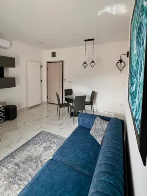 a blue couch in a living room with a table at Apartment Tulip of Becici in Budva
