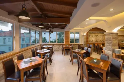 a restaurant with wooden tables and chairs and windows at Villa Ljubanovic in Budva