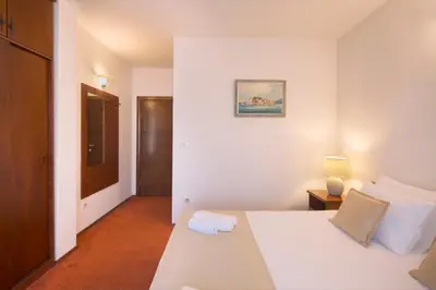 a bedroom with a white bed and a door at Villa Ljubanovic in Budva