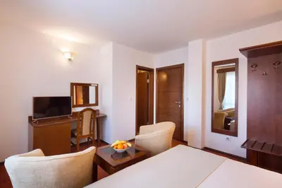a room with a bed and a table and chairs at Villa Ljubanovic in Budva