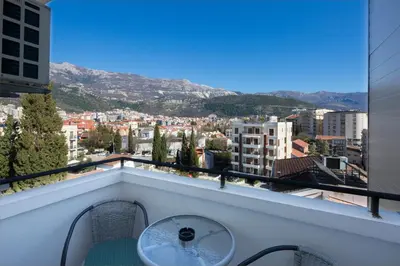 a balcony with a table and a view of a city at Villa Ljubanovic in Budva