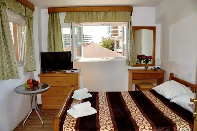 a bedroom with a bed with a table and a window at Apartments Stanivukovic in Budva