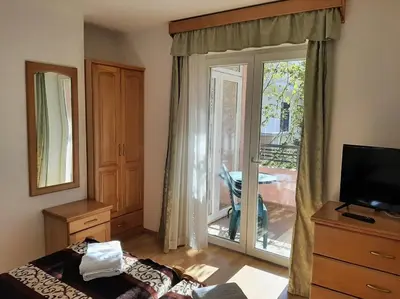 a bedroom with a bed and a sliding glass door at Apartments Stanivukovic in Budva