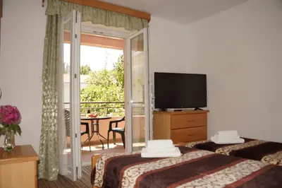 a hotel room with two beds and a balcony at Apartments Stanivukovic in Budva