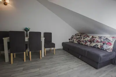 a living room with a couch and a table and chairs at Hotel Dapčević in Cetinje
