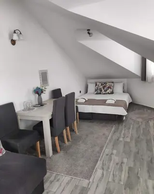 a room with a bed and a table and chairs at Hotel Dapčević in Cetinje