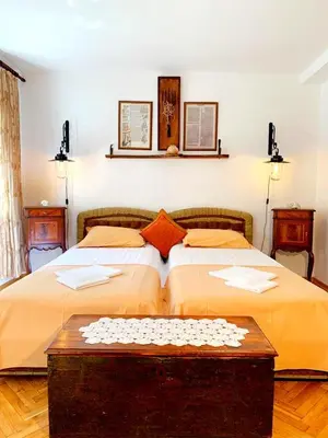 a bedroom with a large bed and a table at Villa Urbana, Old Town Budva in Budva