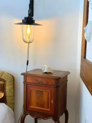a lamp on top of a wooden table next to a bed at Villa Urbana, Old Town Budva in Budva