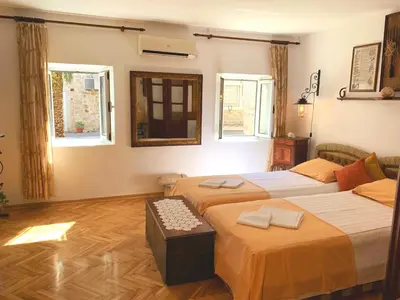 a hotel room with two beds and two windows at Villa Urbana, Old Town Budva in Budva