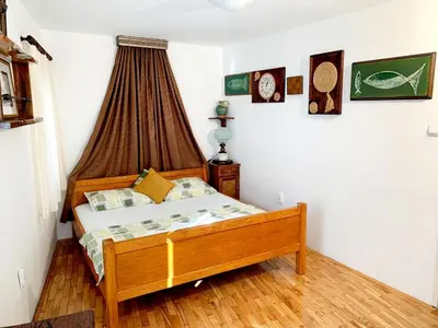 a bedroom with a wooden bed in a room at Villa Urbana, Old Town Budva in Budva