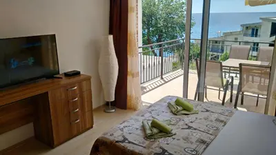 a bedroom with a television and a balcony with a view at Apartments Abramovic 2 in Sutomore