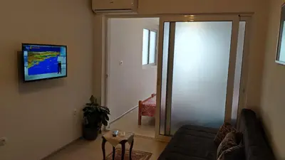 a living room with a couch and a tv on the wall at Apartments Abramovic 2 in Sutomore