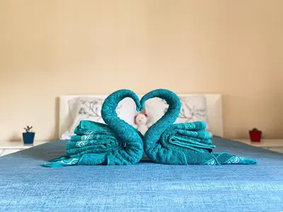 two swansrendered to look like hearts on a bed at ANDI Apartment in Ulcinj