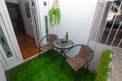a table and chairs on a balcony with green grass at Lea Apartment in Bar