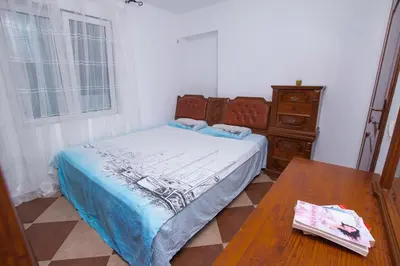 a bedroom with a bed and a wooden table at Lea Apartment in Bar