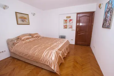 a bedroom with a bed and a wooden floor at Lea Apartment in Bar