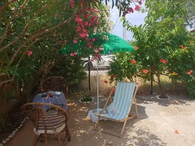 two chairs and an umbrella on a patio at Anna Apartment in Utjeha