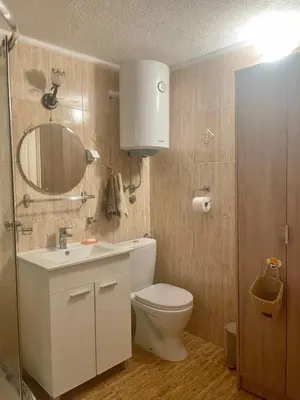 a bathroom with a toilet and a sink and a mirror at Anna Apartment in Utjeha