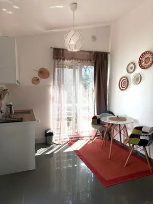 a living room with a table and a kitchen at Anna Apartment in Utjeha