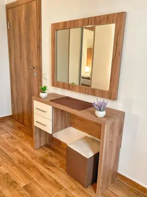 a bathroom with a wooden vanity with a mirror at MD APARTMENTS in Ulcinj