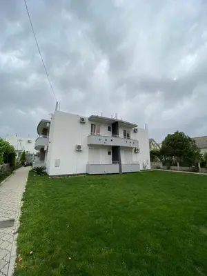 a white house with a green lawn in front of it at MD APARTMENTS in Ulcinj