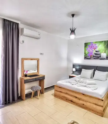 a bedroom with a bed and a desk and a mirror at MD APARTMENTS in Ulcinj