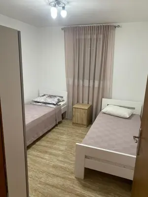 a bedroom with two beds and a window at Apartman 02 in Bar