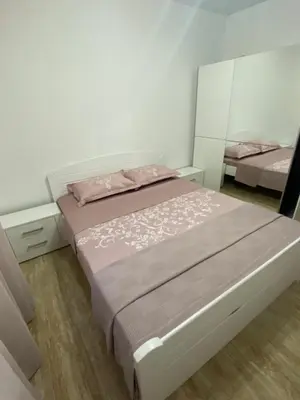 a bedroom with a bed with pink sheets and a mirror at Apartman 02 in Bar