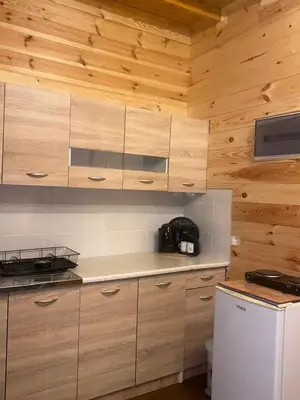a kitchen with wooden cabinets and a refrigerator at Cottage Four Olives in Ulcinj