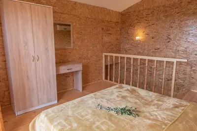 a bedroom with a bed and a cabinet in it at Cottage Four Olives in Ulcinj