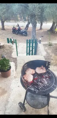 a grill with meat cooking on top of it at Cottage Four Olives in Ulcinj