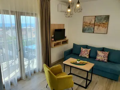 a living room with a blue couch and a table at Family Apartments in Bar