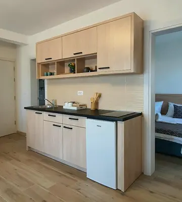 a kitchen with wooden cabinets and a counter top at Family Apartments in Bar