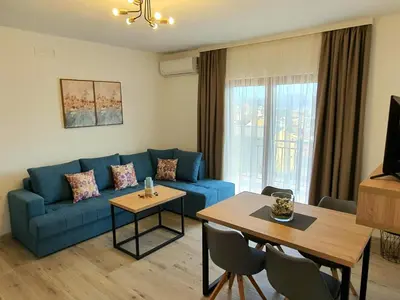 a living room with a blue couch and a table at Family Apartments in Bar