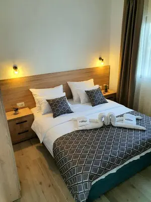 a bedroom with a large bed with white sheets and pillows at Family Apartments in Bar