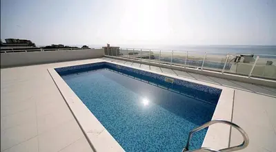 a swimming pool on top of a building with the ocean at Riki Dream in Dobra Voda