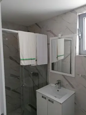 a bathroom with a sink and a shower and a mirror at Riki Dream in Dobra Voda