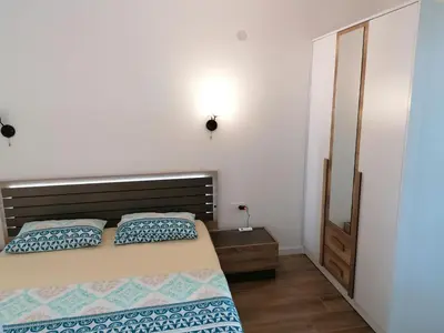 a bedroom with a bed with blue and white pillows at Riki Dream in Dobra Voda