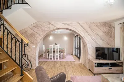 a living room with an archway and a dining room at Guest House Luksic in Bar